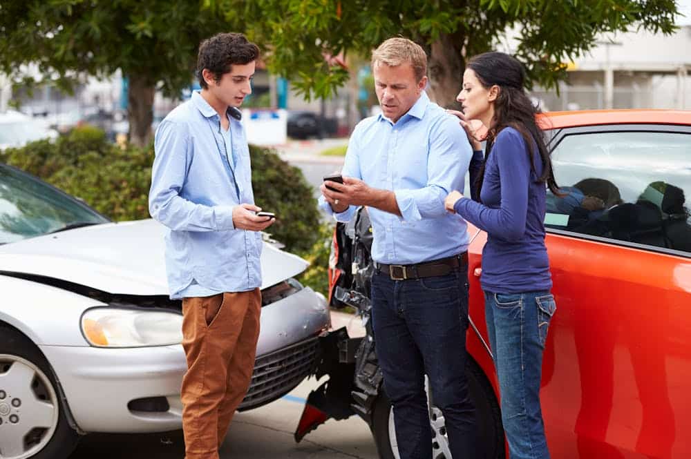 What to Do if the Other Driver Doesnt Have Insurance – Personal Injury Lawyer in Fort Lauderdale People exchanging insurance details after a car accident on a city street.